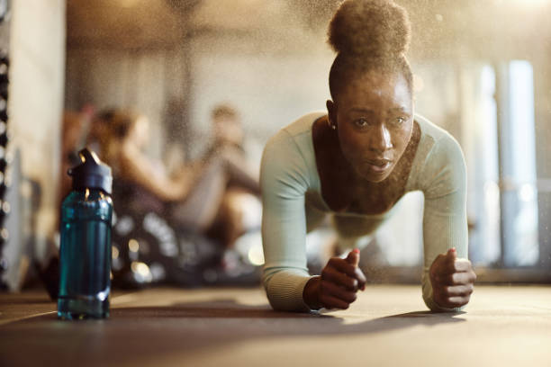 African American athletic woman exercising in plank position in gym
