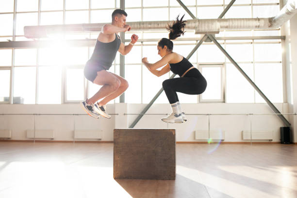 Athletic couple training together in fitness room