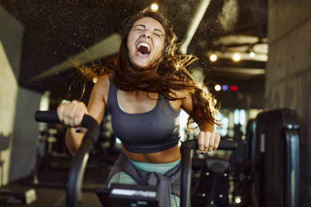 Athletic woman exercising on stationary bike in gym