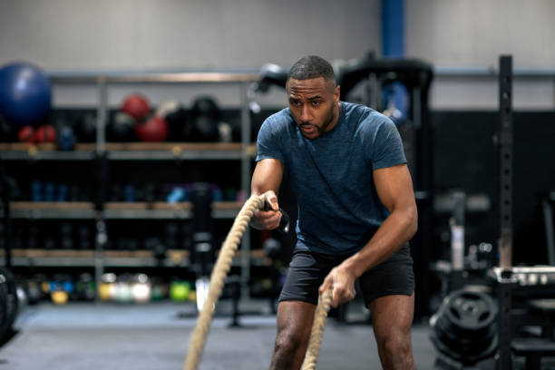 Athlete training with battle ropes in a CrossFit gym