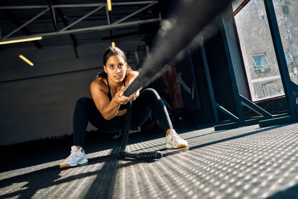 Female athlete pulling weighted sled in gym