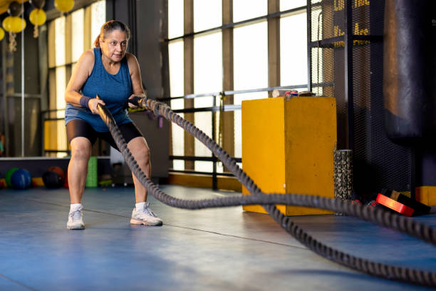 Woman training with battle rope in gym